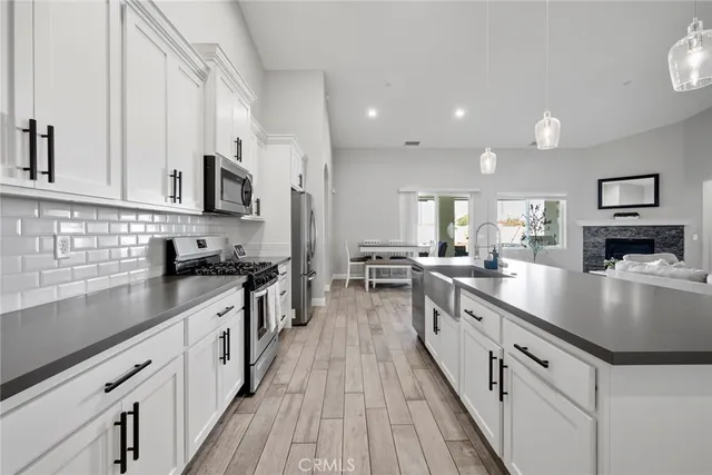 a large kitchen with stainless steel appliances granite countertop a lot of counter space and wooden floors