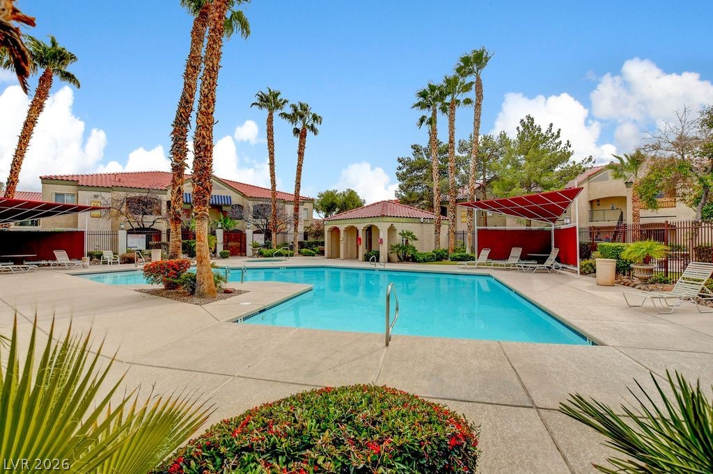 7885 West Flamingo Road, Unit 1079 Las Vegas, NV 89147 - Photo 31 of 35 This inviting community pool area features lush landscaping and a covered lounging space.
