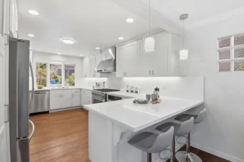 a kitchen with a sink a kitchen island and chairs