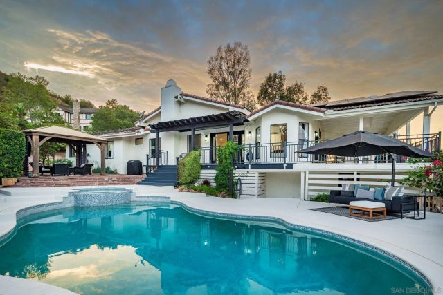 a front view of a house with swimming pool having outdoor seating
