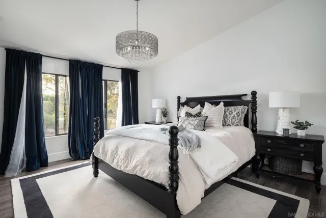 a bedroom with a large bed and a chandelier