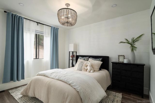 a bedroom with a large bed and a chandelier