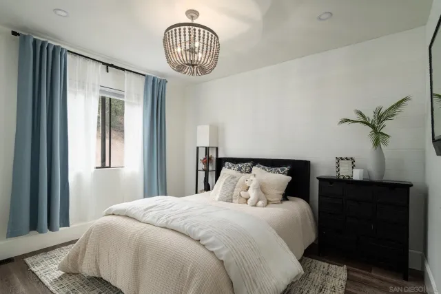 a bedroom with a large bed and a chandelier