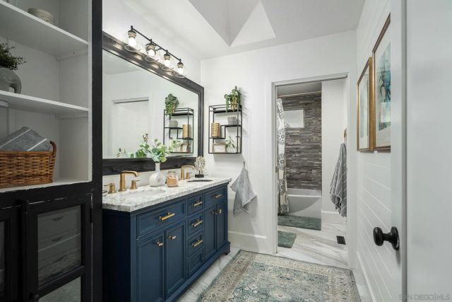a bathroom with a double vanity sink toilet and shower
