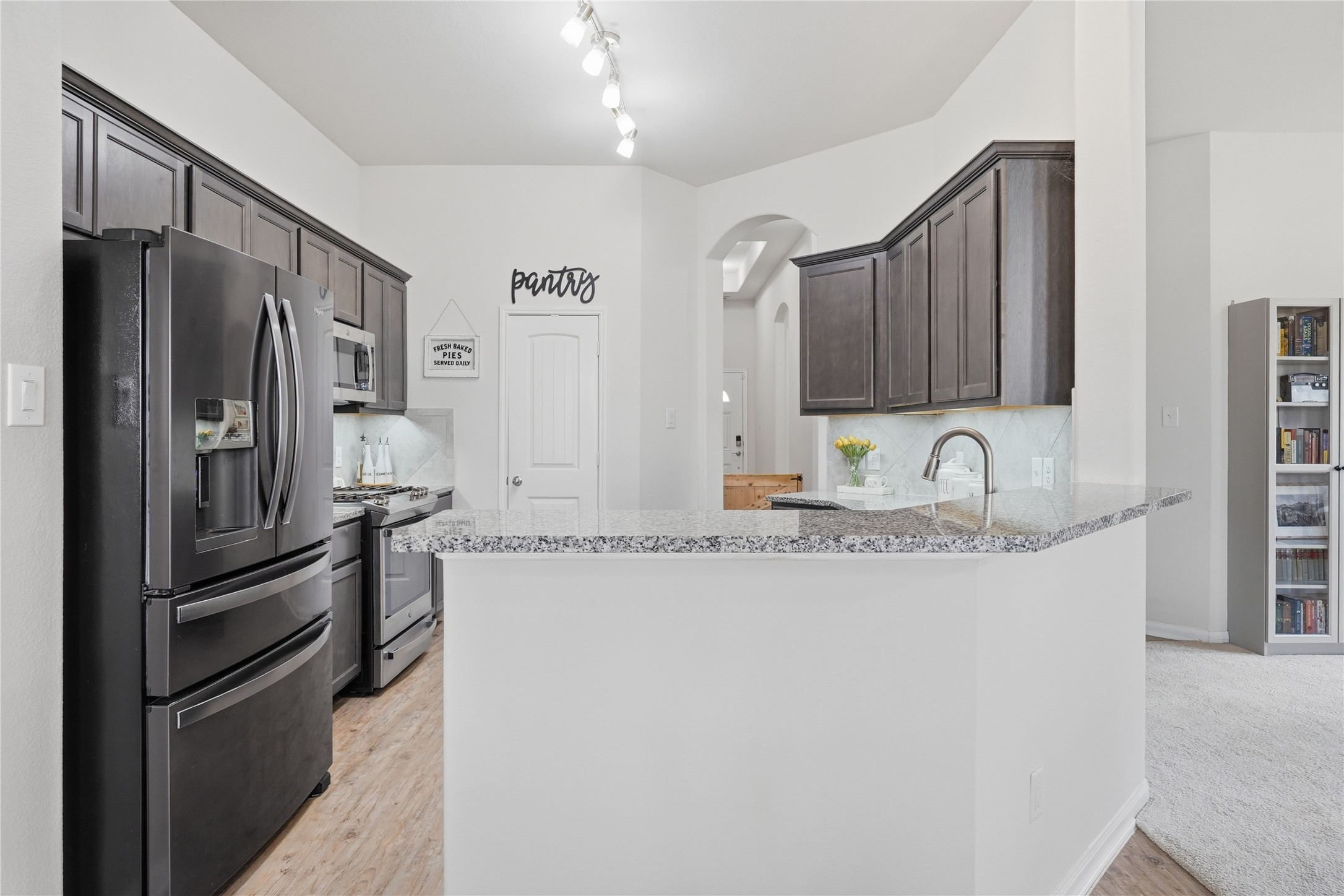 3579 Korina Way Conroe, TX 77306 - Photo 8 of 20 a kitchen with granite countertop a refrigerator and a sink