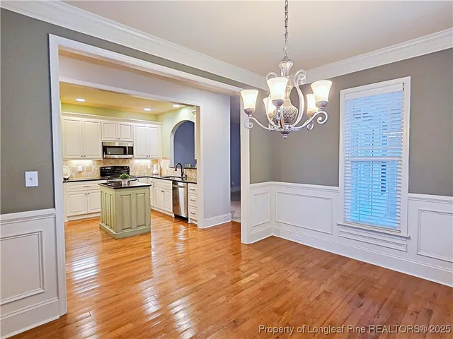 a view of a kitchen with granite countertop a stove top oven a sink and dishwasher with wooden floor