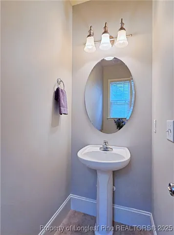 a bathroom with a sink a mirror and a lamp