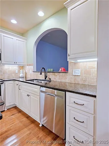 a kitchen with granite countertop white cabinets and white appliances