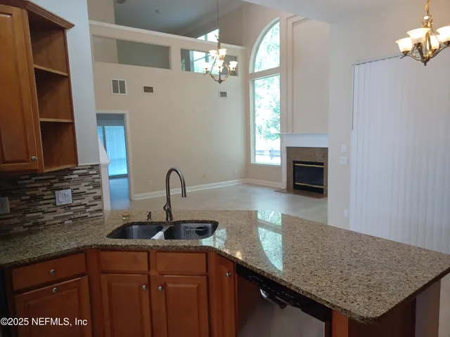 a kitchen with stainless steel appliances granite countertop a sink dishwasher and stove with wooden floor