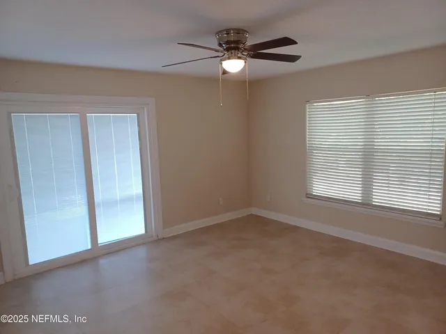 an empty room with a bathroom and a mirror