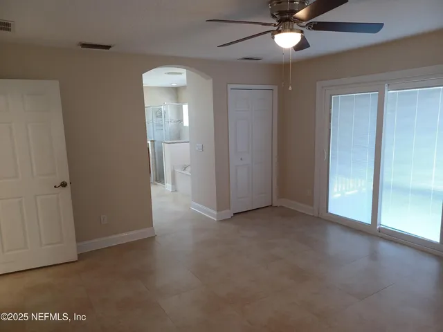 a view of a hallway with wooden floor and a ceiling fan