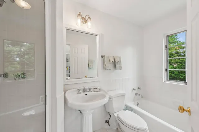 a bathroom with a sink a toilet and shower