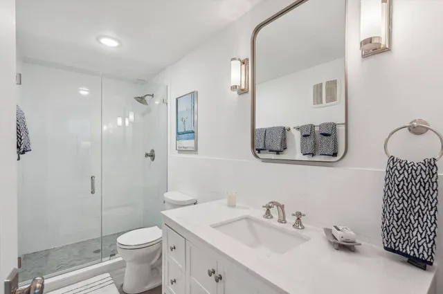 a bathroom with a granite countertop toilet sink and mirror
