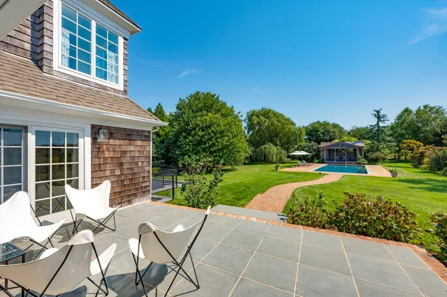 a view of a house with backyard sitting area and garden