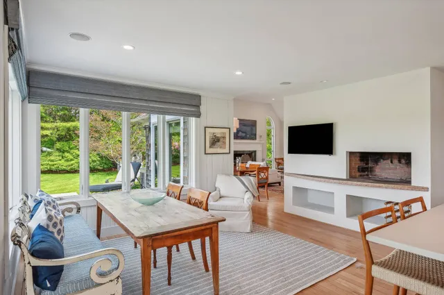 a living room with furniture a flat screen tv and a large window