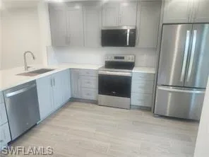a kitchen with stainless steel appliances a refrigerator sink and microwave