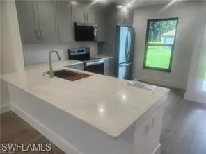 a kitchen with stainless steel appliances a sink and a refrigerator