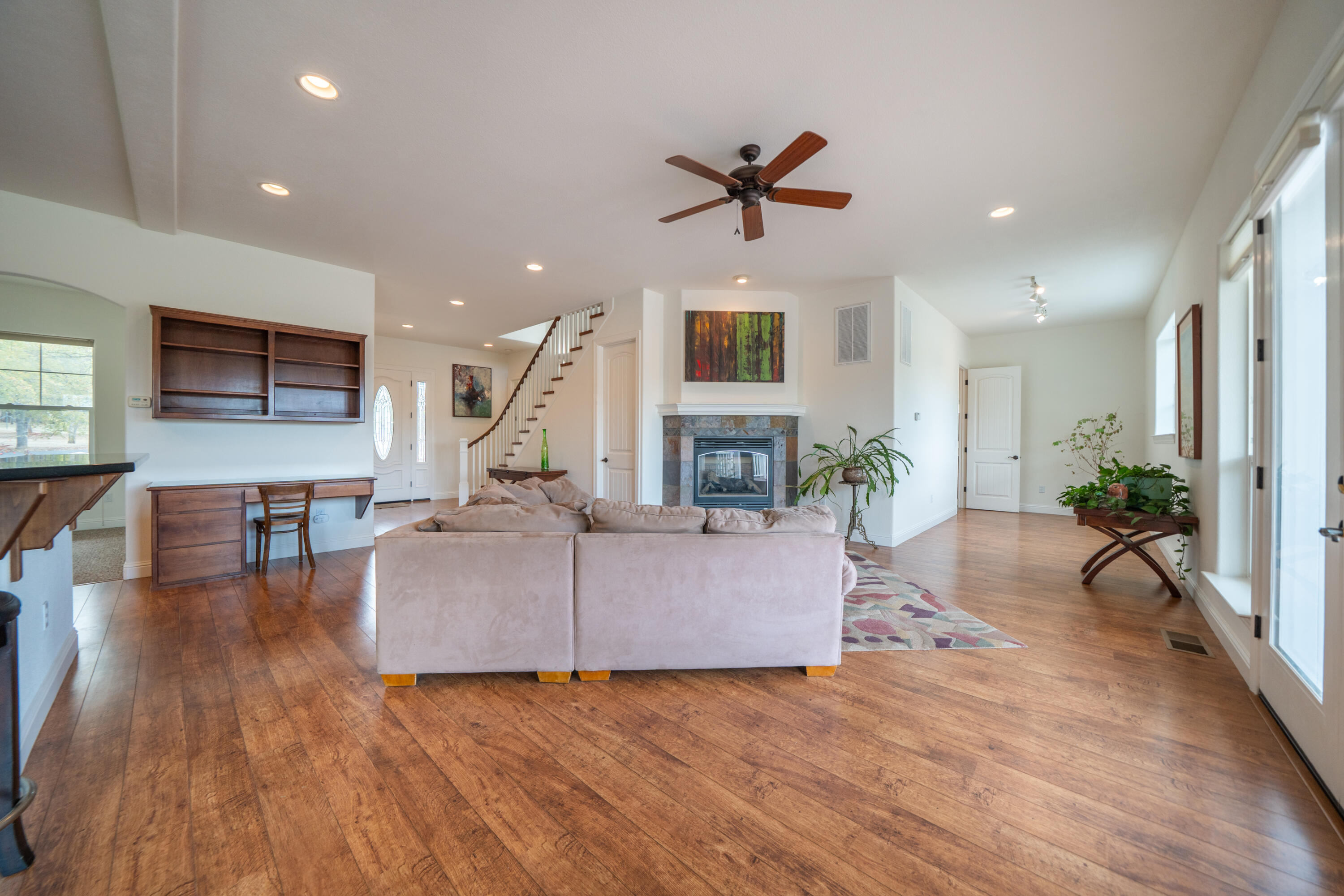 8180 Whispering Oaks Road Redding, CA 96002 - Photo 12 of 100 a living room with furniture a fireplace and a flat screen tv