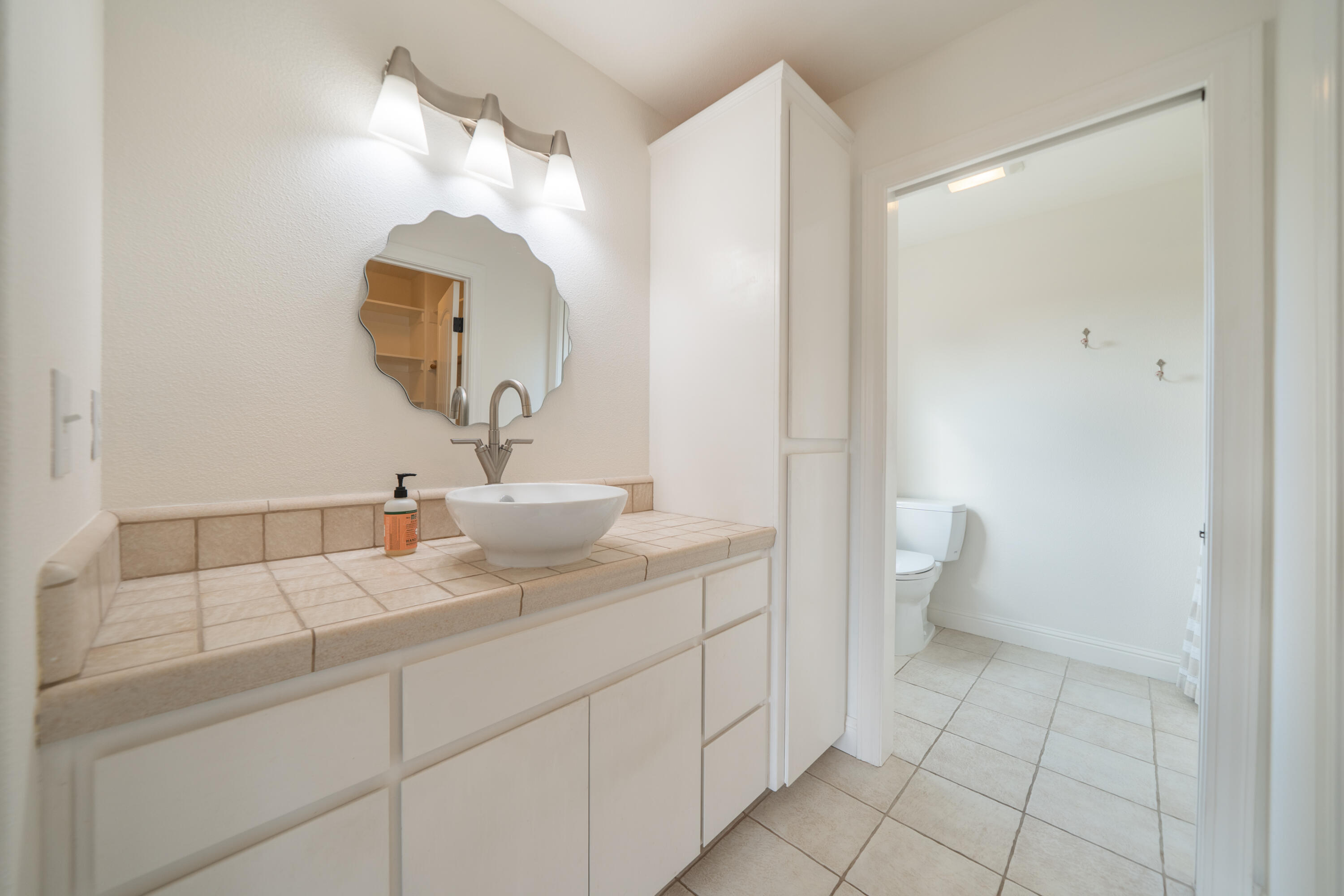 8180 Whispering Oaks Road Redding, CA 96002 - Photo 38 of 100 a bathroom with a sink a toilet and a mirror