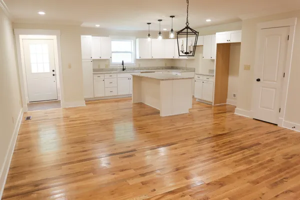 a kitchen with granite countertop white cabinets white appliances and sink