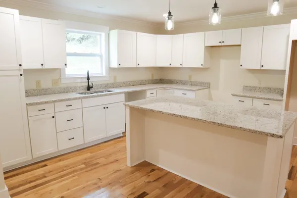 a kitchen with granite countertop white cabinets and stainless steel appliances