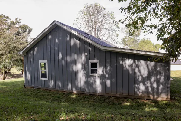 a view of a house with a yard and tree s