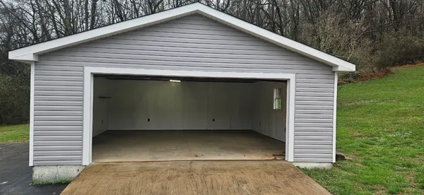 a view of a room with kitchen and wooden floor