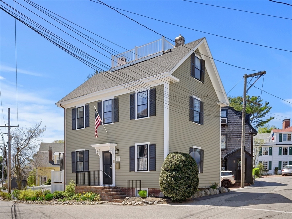 a view of a white house next to a road