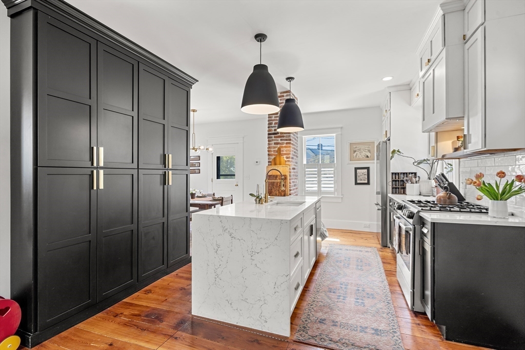 1 Gregory Street Marblehead, MA 01945 - Photo 14 of 42 a kitchen with stainless steel appliances granite countertop a refrigerator a sink dishwasher a stove and a dining table with wooden floor