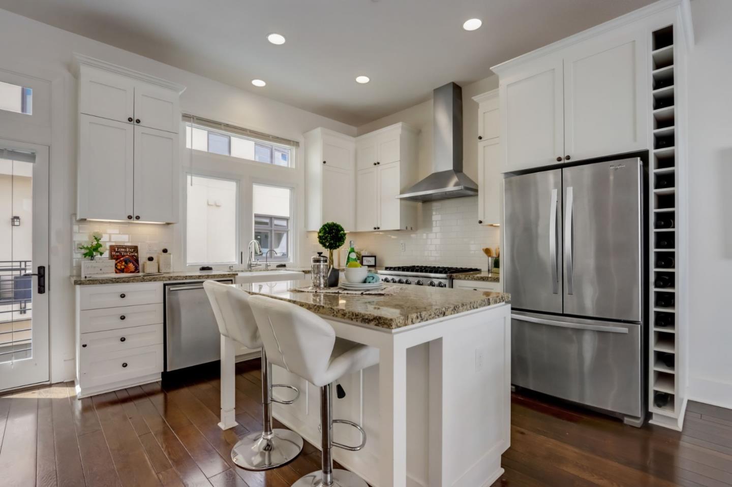 612 Allerton Loop Campbell, CA 95008 - Photo 7 of 38 a kitchen with stainless steel appliances granite countertop a refrigerator a stove a sink dishwasher and white cabinets with wooden floor