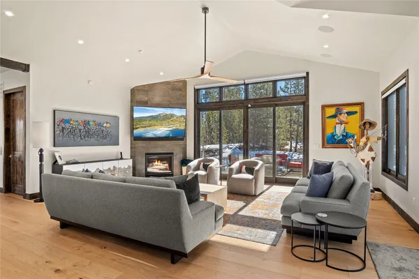 a living room with furniture a floor to ceiling window and a flat screen tv