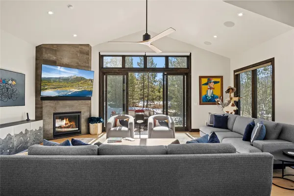 a living room with furniture large windows and a fireplace