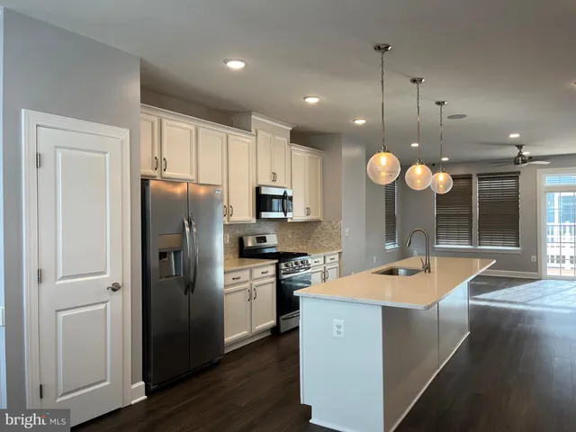 a kitchen with stainless steel appliances granite countertop a sink a stove and a refrigerator