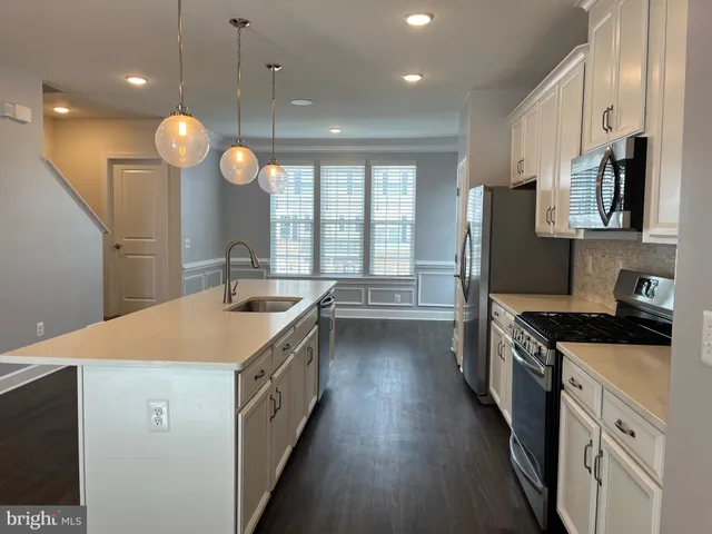 a kitchen with stainless steel appliances a refrigerator a stove a sink and microwave