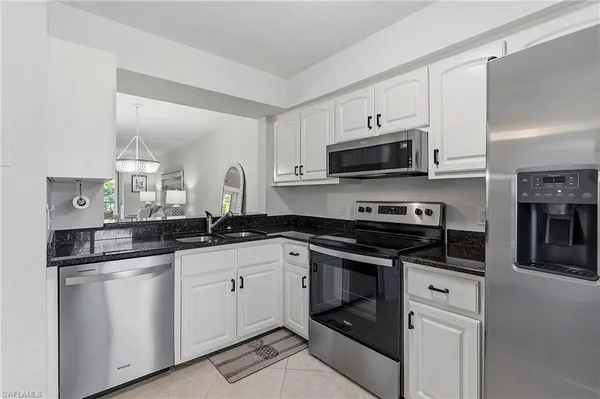 a kitchen with granite countertop a sink and stainless steel appliances