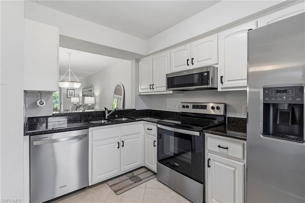a kitchen with granite countertop a sink and stainless steel appliances