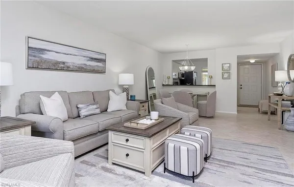 a living room with furniture a flat screen tv and a table