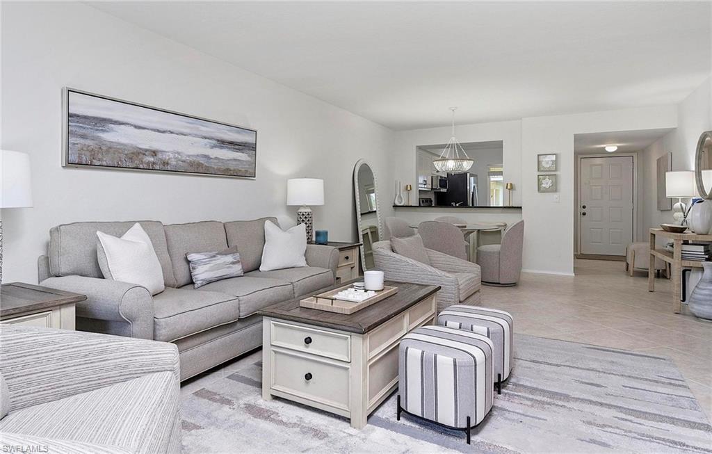 1001 Foxfire Lane, Unit 307 Naples, FL 34104 - Photo 11 of 23 a living room with furniture a flat screen tv and a table