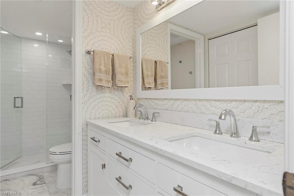 1001 Foxfire Lane, Unit 307 Naples, FL 34104 - Photo 16 of 23 a bathroom with a sink a toilet and a mirror