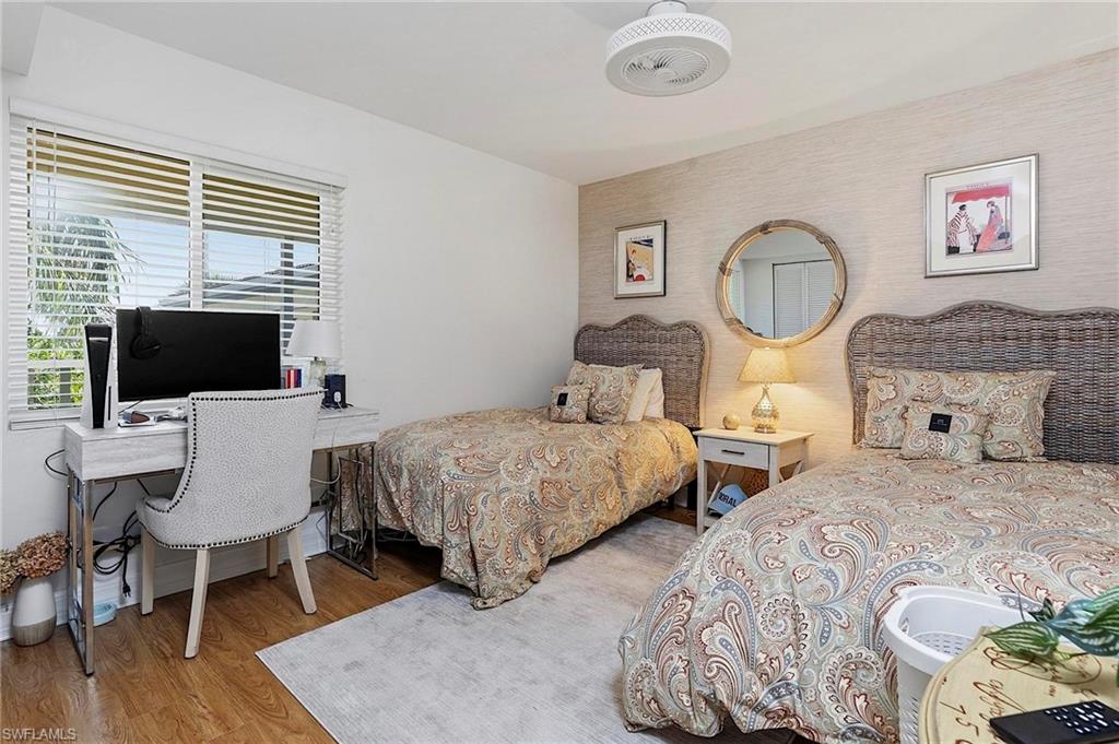 1001 Foxfire Lane, Unit 307 Naples, FL 34104 - Photo 18 of 23 a bedroom with two beds and a flat screen tv