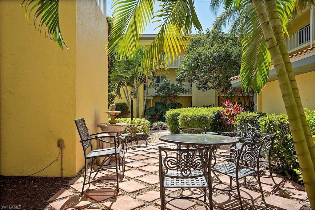1001 Foxfire Lane, Unit 307 Naples, FL 34104 - Photo 19 of 23 a view of a patio with table and chairs and potted plants