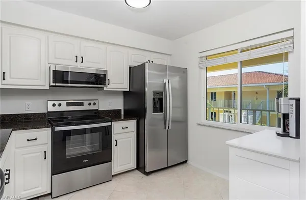 a kitchen with stainless steel appliances a stove a microwave and a sink