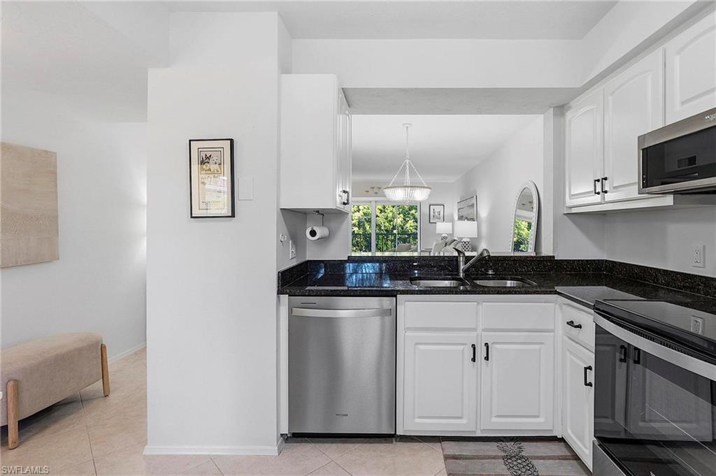 1001 Foxfire Lane, Unit 307 Naples, FL 34104 - Photo 3 of 23 a kitchen with stainless steel appliances granite countertop a sink and a stove