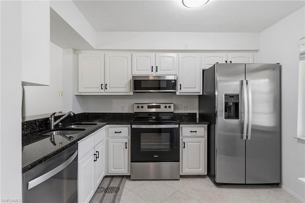 1001 Foxfire Lane, Unit 307 Naples, FL 34104 - Photo 4 of 23 a kitchen with stainless steel appliances granite countertop a refrigerator a stove and a sink with granite countertops