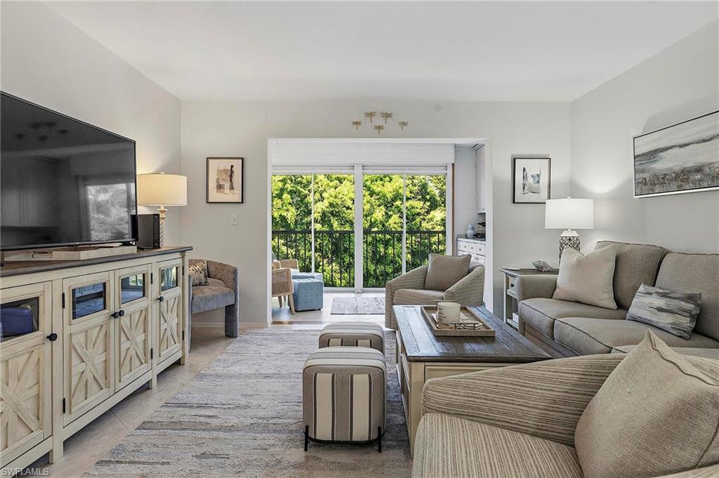 1001 Foxfire Lane, Unit 307 Naples, FL 34104 - Photo 9 of 23 a living room with furniture and a flat screen tv