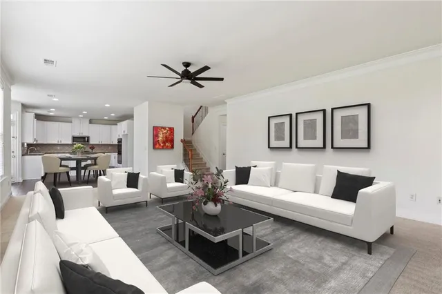 a living room with furniture kitchen view and a wooden floor