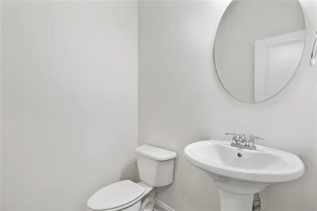 a bathroom with a sink a mirror and toilet