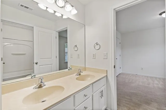 a bathroom with a sink a light fixture and a mirror