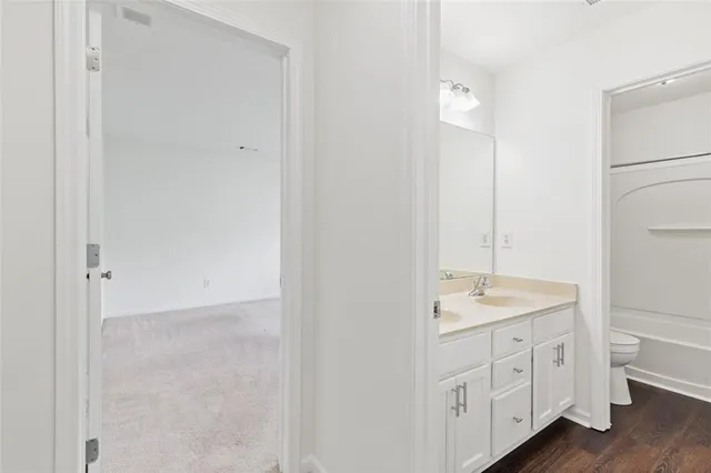 a spacious bathroom with a granite countertop sink and a mirror