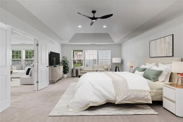 a spacious bedroom with a large bed a flat screen tv and a window